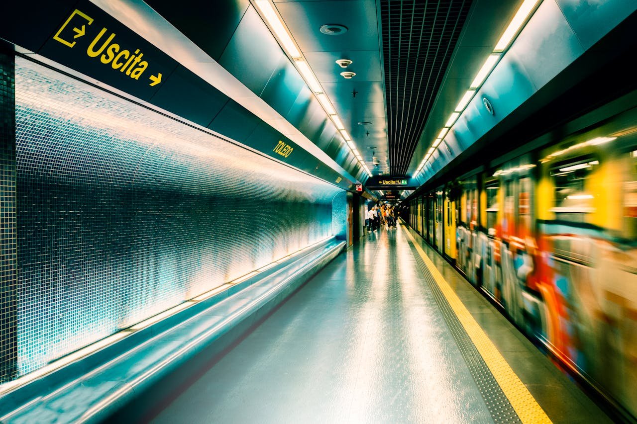 Dynamic scene of a subway station in Napoli with a moving train and illuminated signage.